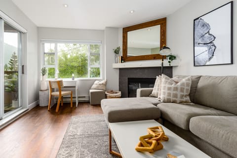 Living Room - Large couch with lounger (converts to queen sofa bed), cozy fireplace, work desk with mountain view.
