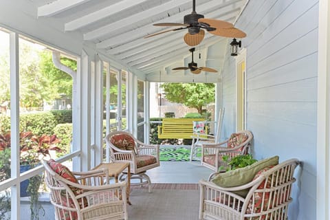 Enjoy sitting and relaxing in this large screened-in porch with lots of seating.