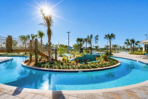 Resort lazy river with tropical landscaping and wooden bridge