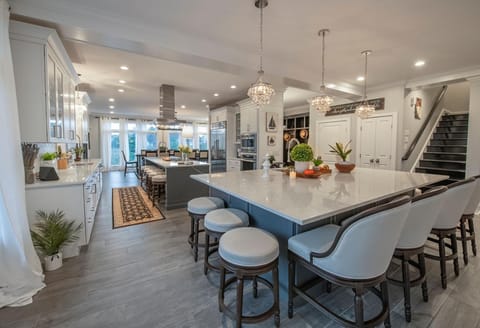 The 2nd-floor chef's kitchen features a large island with a built-in sink, beverage fridge, and plenty of seating—ideal for cooking, entertaining, and gathering.