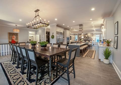Stunning 2nd-floor dining room opens to a chef's kitchen and extends to a 2nd-level deck with an outdoor kitchen and views of the pool, bay, and ocean—a perfect setup for indoor-outdoor dining.