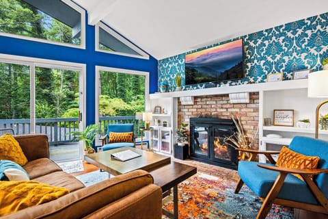 Cozy living room with LED Smart TV, Bluetooth speaker, and lush furniture.