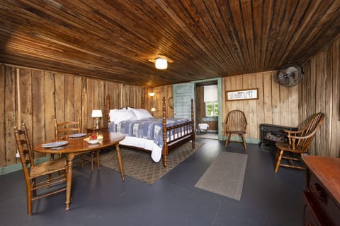 Inside Cellar House-full size bed, sitting area. Bathroom has tub/shower combo.