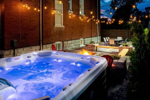 Relax in the private backyard featuring a large hot tub and twinkling string lights.