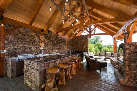 Outdoor pavilion with grill, pizza oven, firepit, hot tub, and m