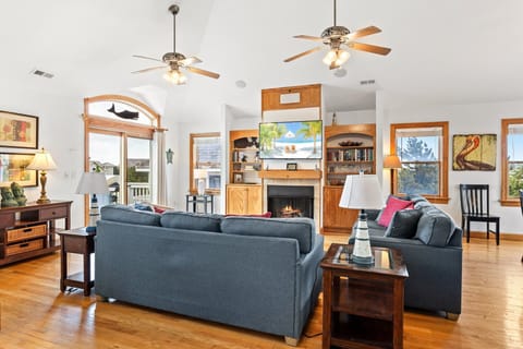 Living Area: Gather with family in the spacious living room with vaulted ceilings, cozy fireplace, and large smart TV.