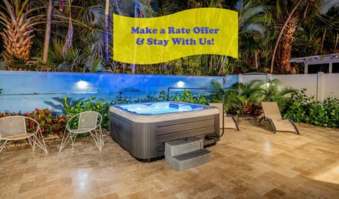 Relax in the private backyard patio with amazing views day & night and amenities that include a soothing hot tub, hammock for two, lounge chairs, BBQ grill and picnic style dining table all surrounded by ocean-themed murals and tropical landscaping.