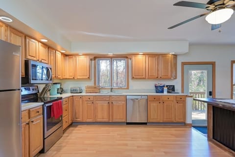 Large fully stocked kitchen with stainless steel appliances and bar top seating