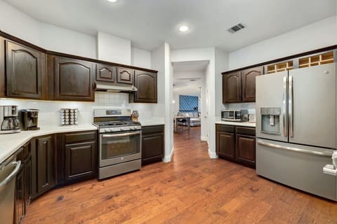 A spacious kitchen with stainless appliances, warm wood floors, and an open layout makes hosting effortless with A Stay Above The Rest.