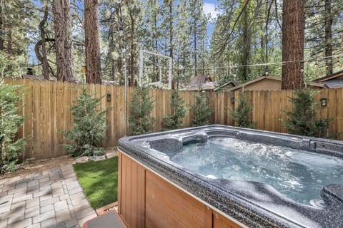 Private outdoor hot tub, surrounded by tall pines, perfect for relaxing under the trees after a day of adventure—enjoy peaceful forest views, fresh air, and a truly rejuvenating stay.