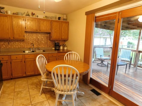 Kitchen with outdoor covered deck through sliding door leading to fenced yard