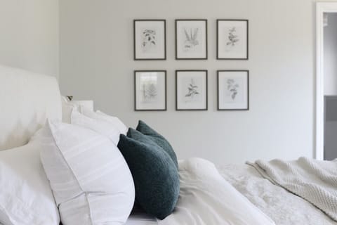 Primary bedroom has a comfortable, upholstered king-sized bed. 