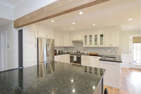 Fully stocked kitchen has room for 6 at the island and more at the table nearby.