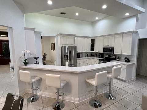 Kitchen with a bar chairs