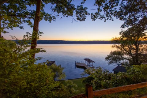 Red Oak Retreat | Seneca Lake Waterfront Home | 3 Bed, 2 bath + Seasonal Bedroom | Two flights of stairs lead down the flat grass beach area, the boathouse, and permanent dock with electric boat lift | Boat lift available for use with owner permission