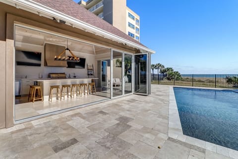 Luxury Indoor/Outdoor Entertaining Space with 2 Flat Screen TVs,  Heated Private Pool, Fenced Patio Area, and Gorgeous Direct Oceanfront Views (Interior Grill Not For Guest Use- Exterior Gas Grill Provided)