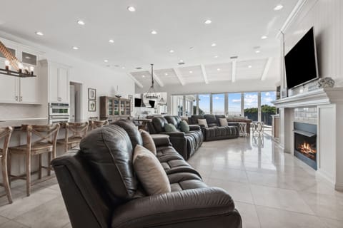 Great Room with Ample Seating, Flat Screen TV, Gas Log Fireplace, and Wall to Wall Doors with Oceanfront Views