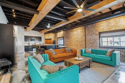 The living area features a smart TV and three couches for ample seating. One couch pulls out to a luxury sofa bed. 