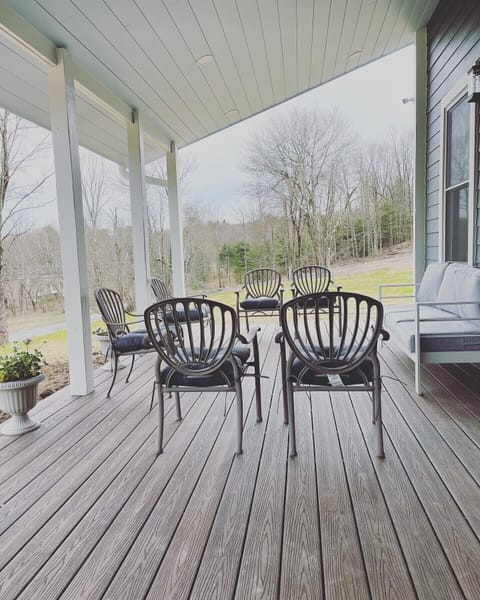 Enjoy the front porch, furnished with outdoor seating and a 12’ dining table. 