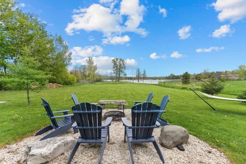 Pull an Adirondack up to the fire and look straight out toward Sawyer Harbor. Open water, open sky, and nothing between you and it — this is the view from your chair.