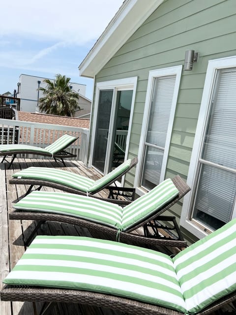 Third floor deck with four lounge chairs.  