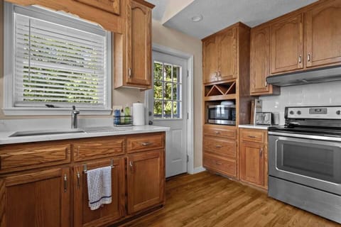 Fully equipped kitchen with all the essentials for preparing meals, including a fridge, stove, microwave, and BBQ utensils.