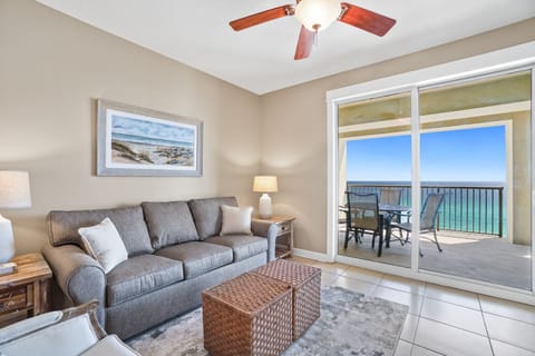 Your coastal living room awaits with plush seating and stunning ocean views through floor-to-ceiling windows that frame the turquoise waters perfectly.