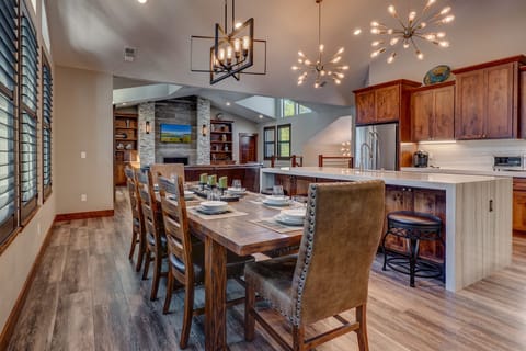 - Dining room with large rustic table and seating  
- Overlooks kitchen and living area with fireplace  
- Open-concept design for family meals and gatherings
