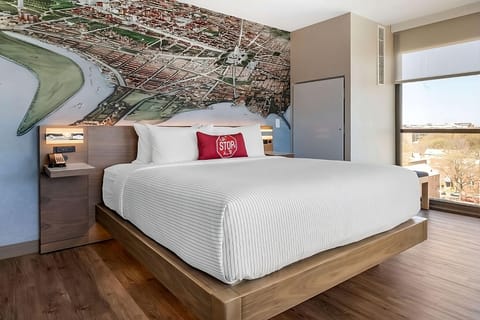 Sink into crisp linens beneath a bold cityscape mural.
