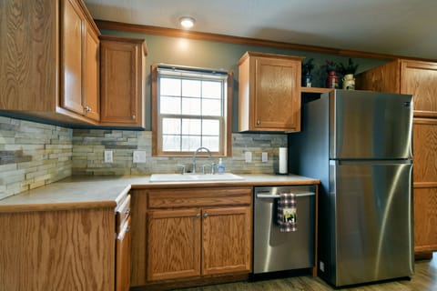 Kitchen skink with view of the backyard fire pit and the lake, and dishwasher. 