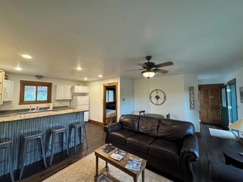 Experience the comfort of our open-concept living area and kitchen, great for socializing and relaxation. The space features a cozy seating area, a smart TV, and a fully equipped kitchen with a breakfast bar for casual dining or morning coffee.