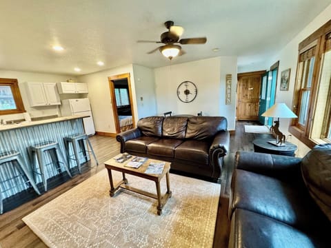 Experience the comfort of our open-concept living area and kitchen, great for socializing and relaxation. The space features a cozy seating area, a smart TV, and a fully equipped kitchen with a breakfast bar for casual dining or morning coffee.