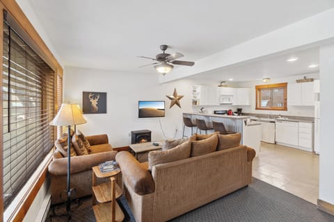 Experience the comfort of our open-concept living area and kitchen, great for socializing and relaxation. The space features a cozy seating area, a smart TV, and a fully equipped kitchen with a breakfast bar for casual dining or morning coffee.