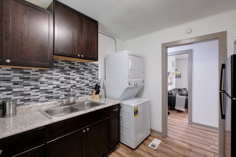 Kitchen  with fridge , oven, microwave and range. Pots  and pans with utensils 