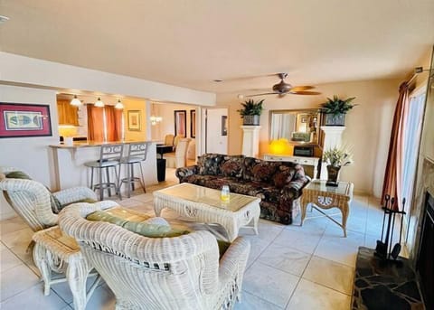 Relax in your spacious tropical living room with comfortable wicker seating and an open kitchen perfect for vacation meals.