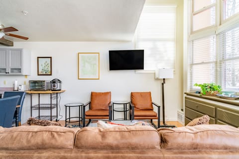 Comfortable couch, additional seating, and a TV in the living room.