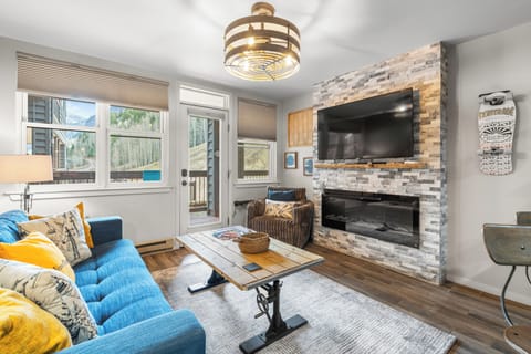 Cozy living room with mountain views and a stone fireplace.