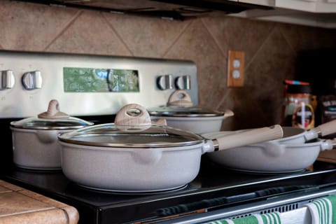 Close-up view of a modern stovetop with stylish cookware, ready for cooking.
