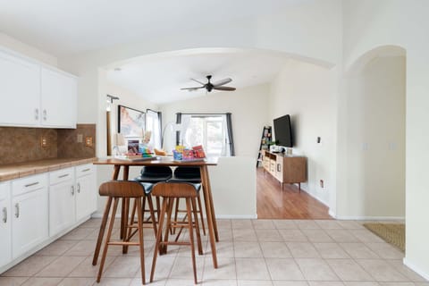 Open-concept kitchen and living area with a central island, modern bar stools, and a cozy living room setup.