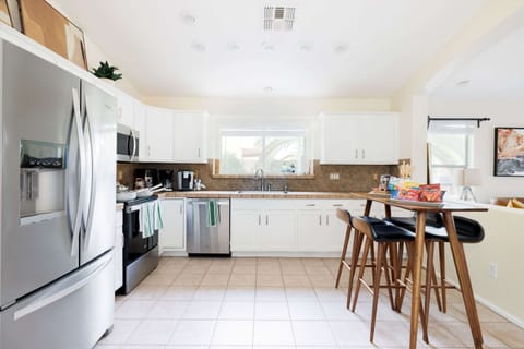 Bright kitchen with stainless steel appliances, white cabinets, and a cozy breakfast table.