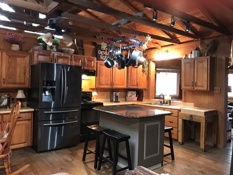 Open area kitchen with sit-around-island and large butcher block.