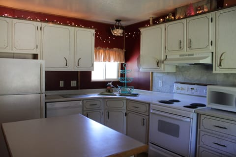 Full kitchen with refrigerator, dishwasher, stove, coffee maker, and microwave.