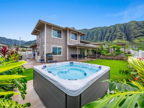 Private hot tub in lush backyard with ocean and mountain views