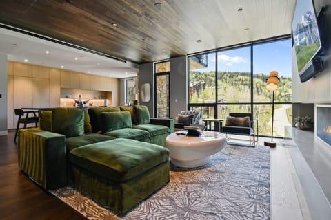 Sink into this plush sofa and gaze out at stunning mountain and forest views through floor-to-ceiling windows—your perfect spot to unwind after a day of adventure.