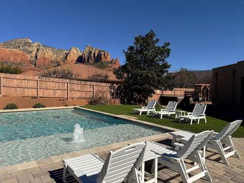 Glowing red rock views from the backyard oasis, complete with pool loungers and water features
