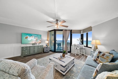 Bright living room with cozy seating and stunning Gulf views from the private balcony.