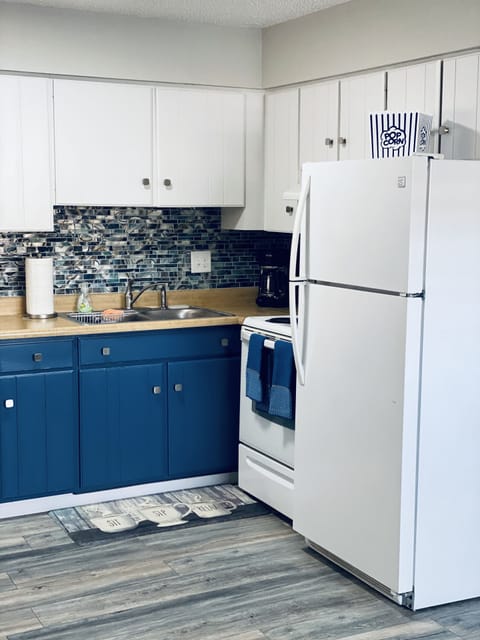 Kitchen with stove/oven, fridge, microwave,  and coffee pot