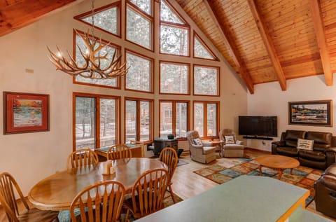 Open dining, kitchen, and living with floor to ceiling windows