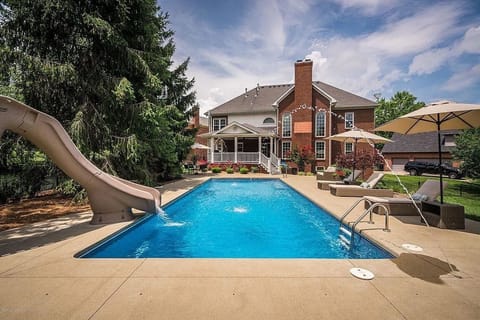 pool and back of house that includes covered patio