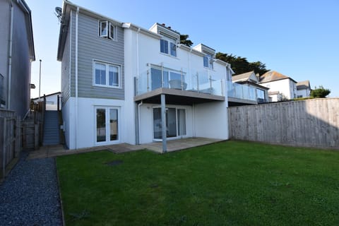 The rear of the property with a generous garden and patio area for dining 